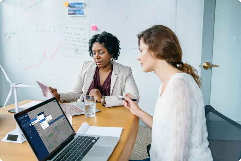 Two TillerStack colleagues reviewing the TSentra dashboard together in a meeting room