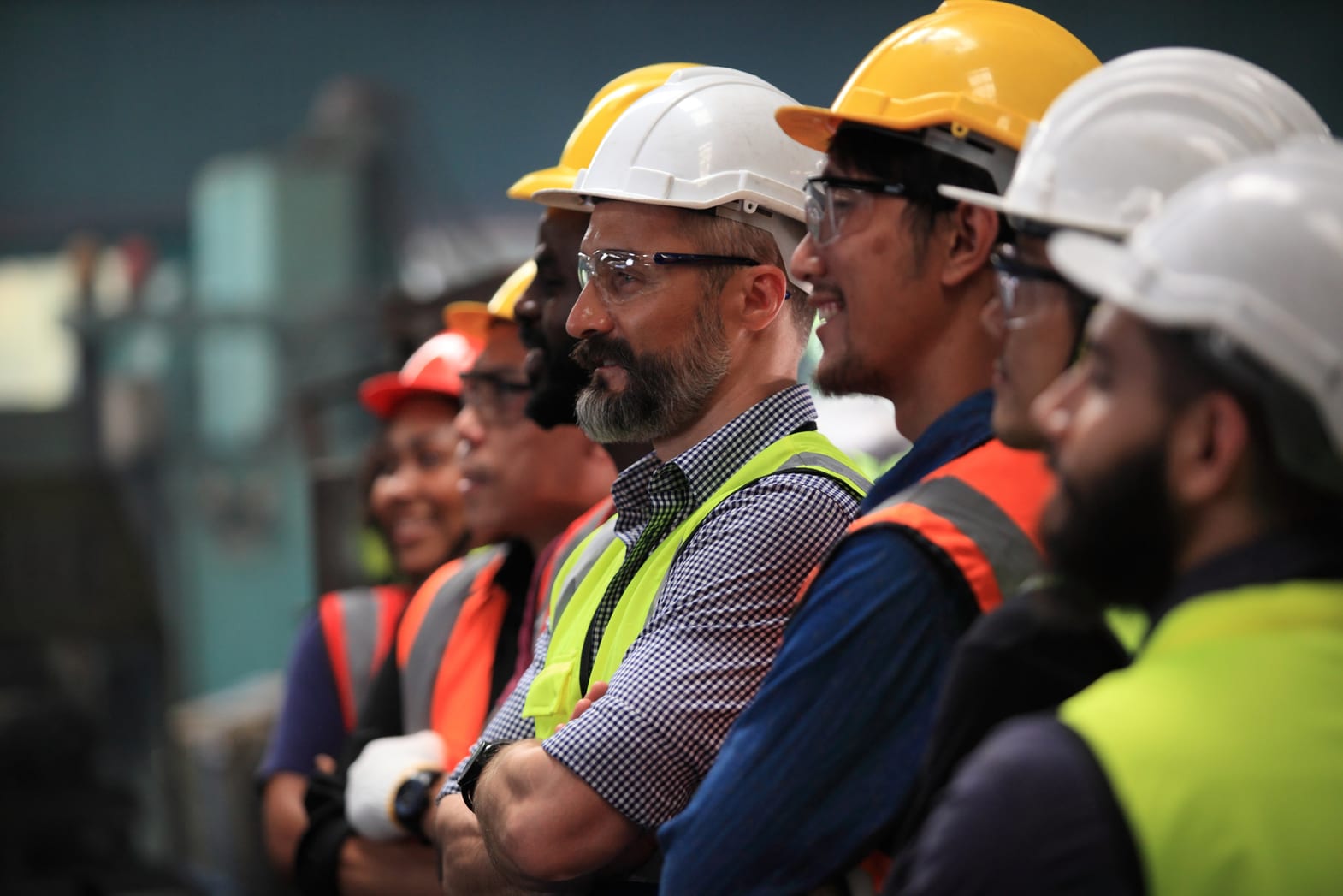 A line of field service technicians in hard hats and high-visibility vests on site