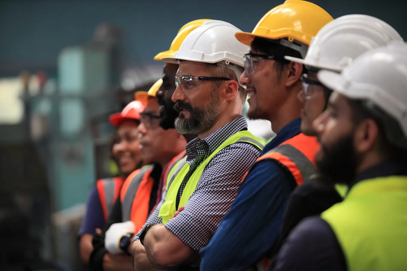 A line of field service technicians in hard hats and high-visibility vests on site